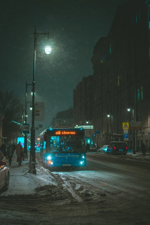 city bus at night near sidewalk in snowy area