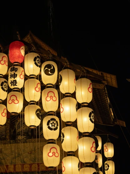 there is a number of small lanterns hanging on the building