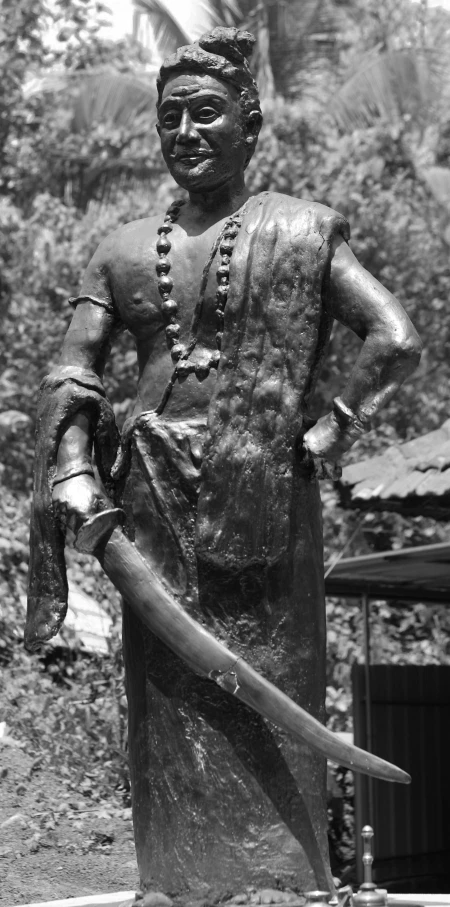 a bronze statue of a man wearing a helmet and holding a sword