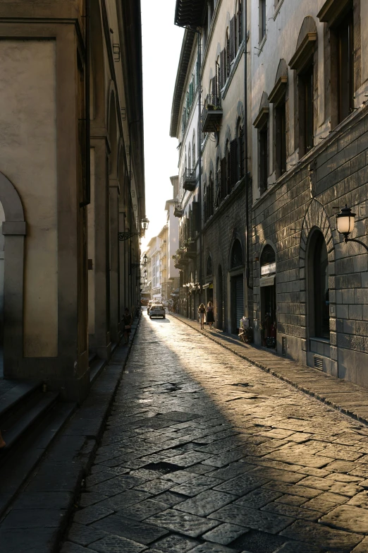 the woman walks down an empty alley in an old town