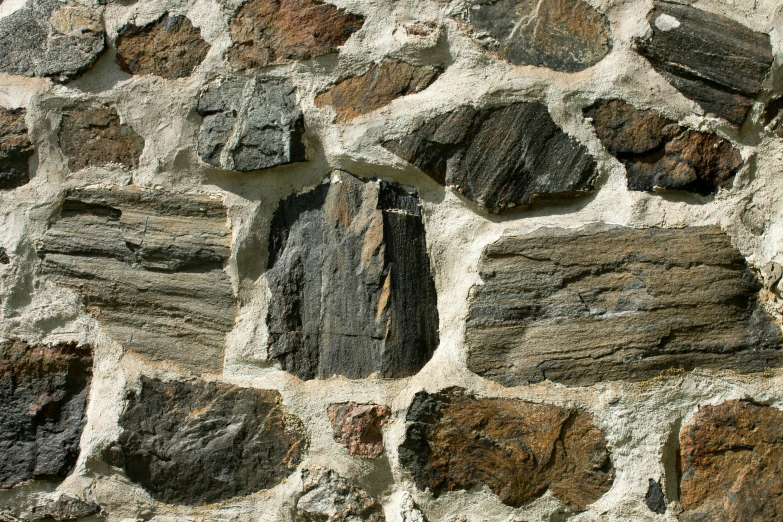 a close up of the side of a stone wall with various stones