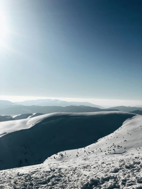 a snowboarder on top of a hill with a mountain in the background