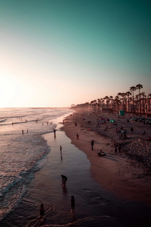 people on the beach, with some swimming