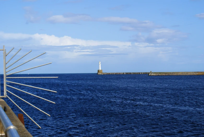 a large body of water with a lighthouse in the distance