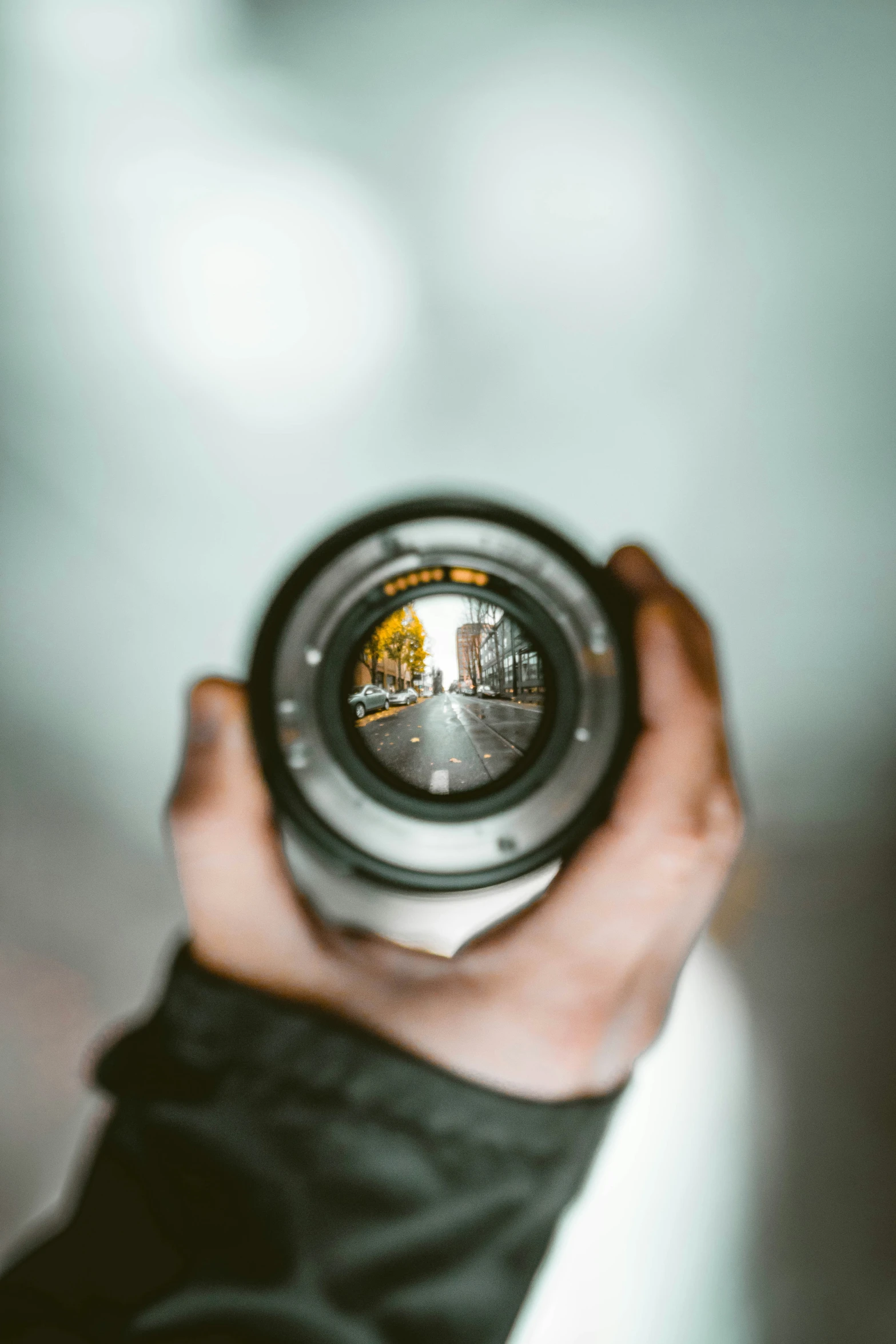 a close up of a person holding a camera with their reflection