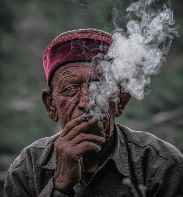 a man is smoking a cigarette with smoke pouring out