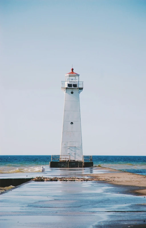 a big tower standing in the water with an ocean behind it