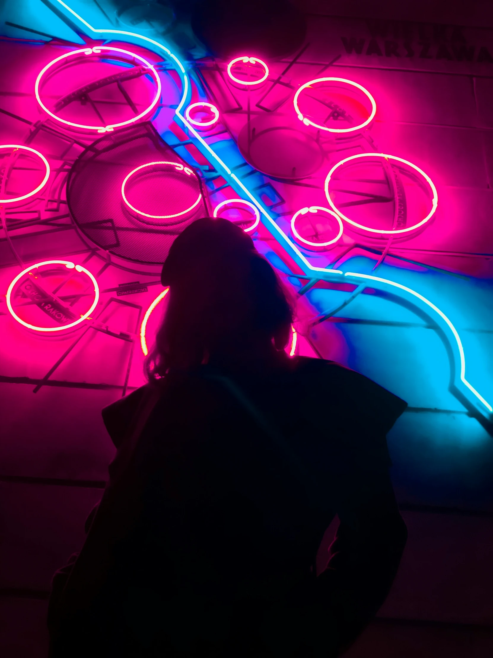 a person standing in front of a neon colored wall