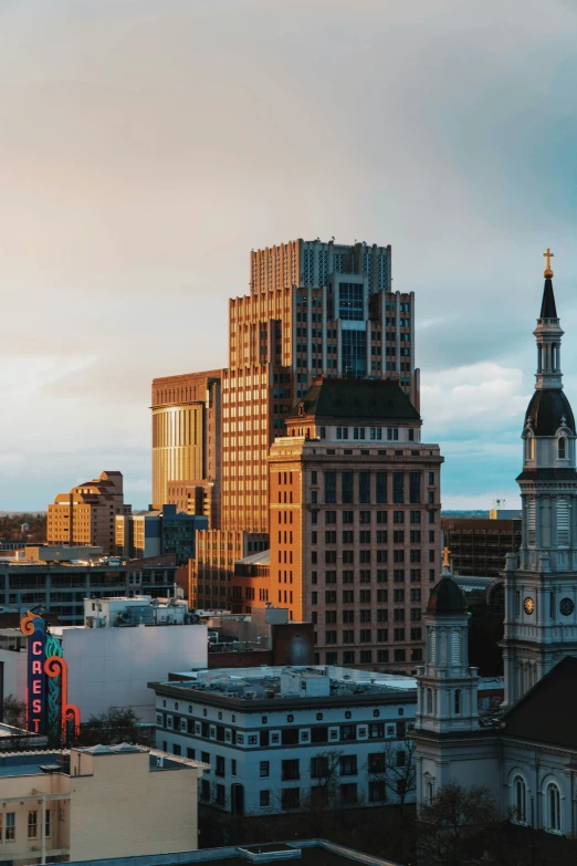 a very tall building sitting in the city next to some other buildings