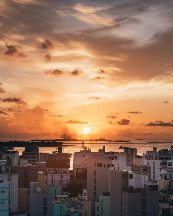 a sunrise seen through the clouds with apartment buildings