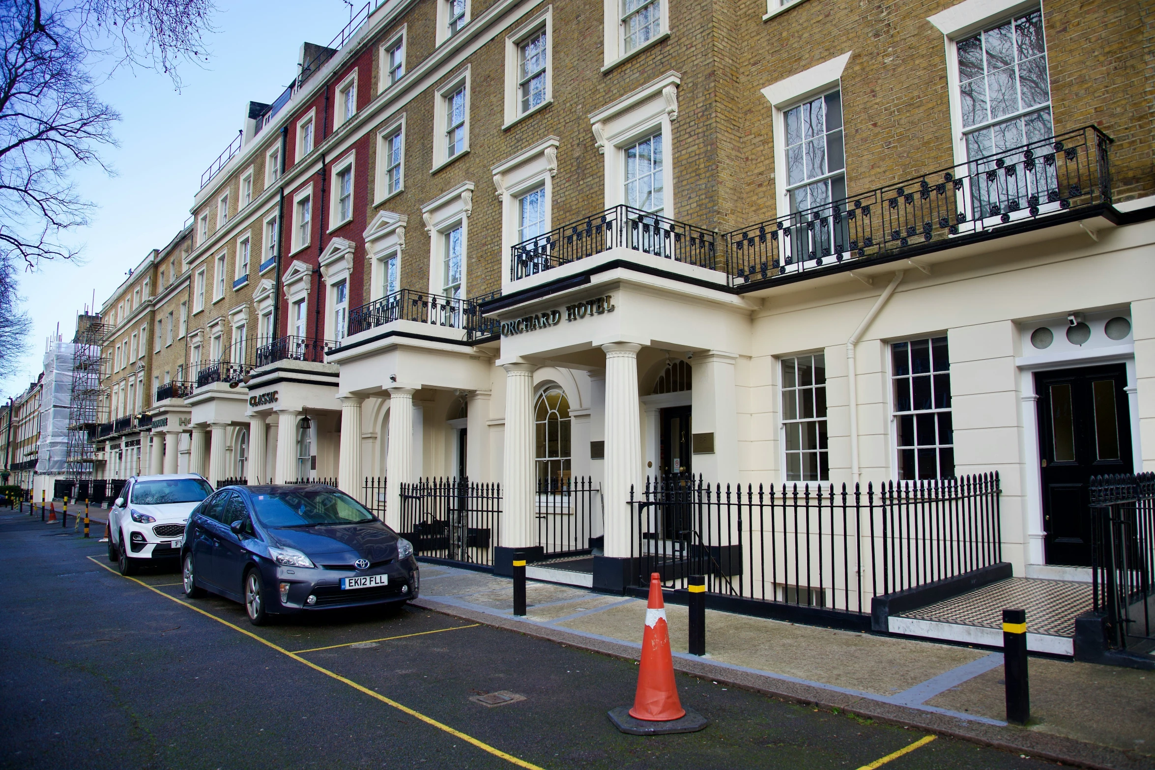 a car parked on the side of the street in front of a row of buildings