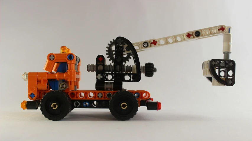 the lego truck with its gear is sitting in front of a large object