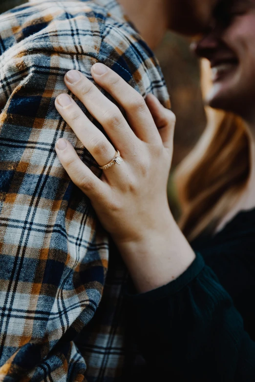 the hands on the shoulders of the person with a yellow diamond ring