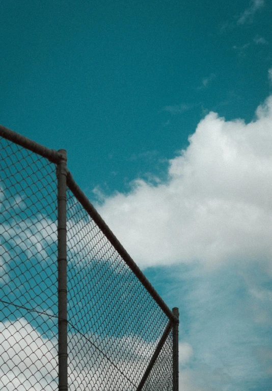 a person with skis standing behind a metal fence