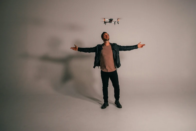 man standing with arms outstretched in front of a white background