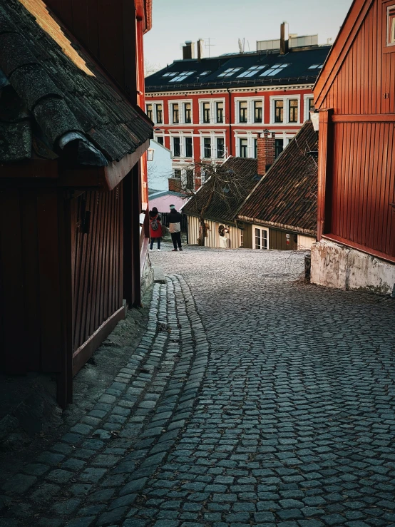 cobblestone walkway and red building on far side of the street