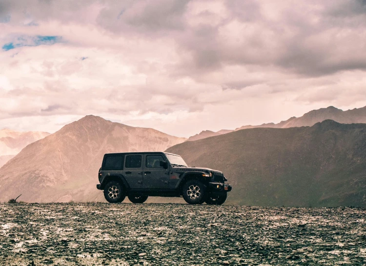 a black jeep parked on a rocky road in the mountains