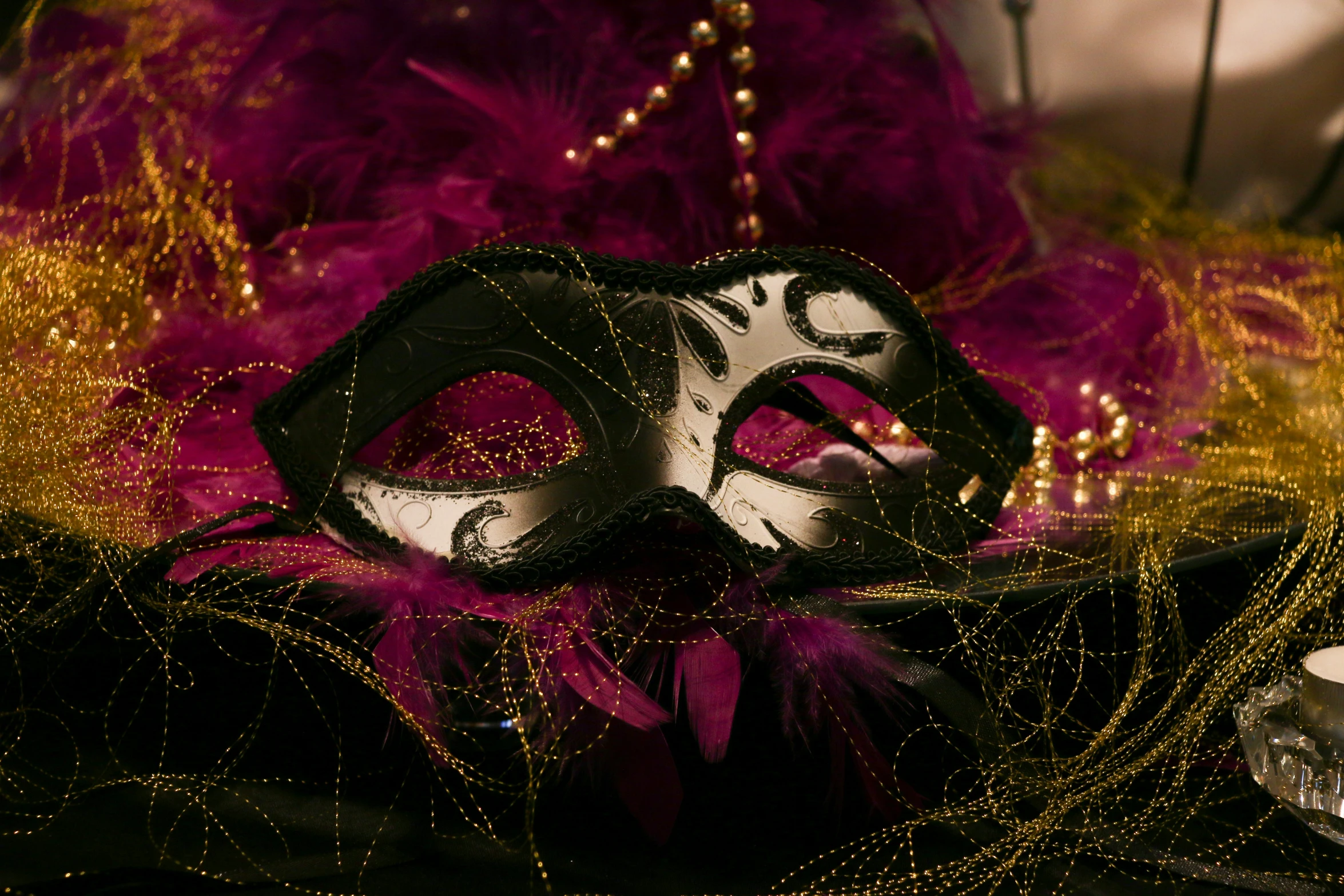 a black and silver mask on a red and gold background