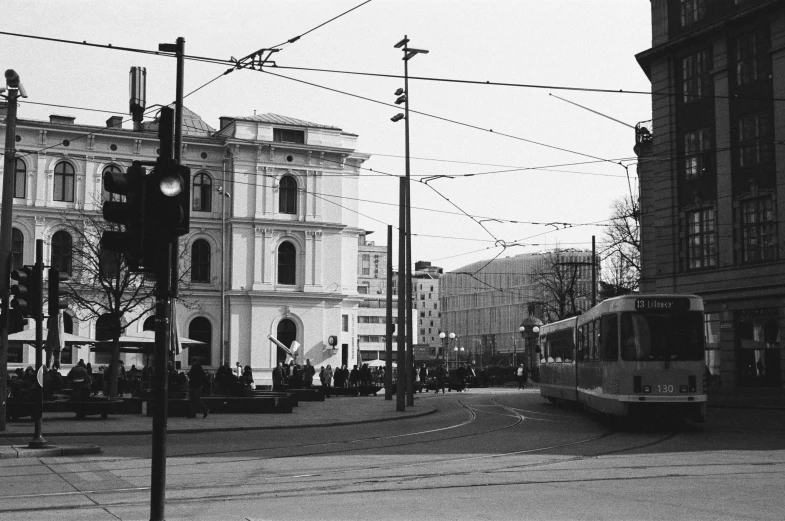 old train moving down a street next to tall buildings