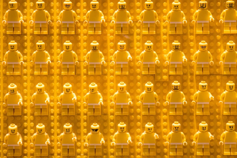 the wall is covered in yellow legos of different colors and sizes