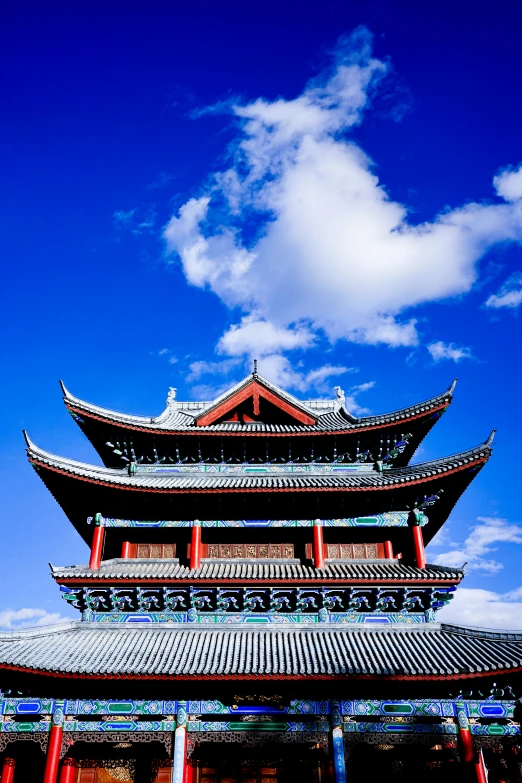 a blue sky with clouds over a tall building