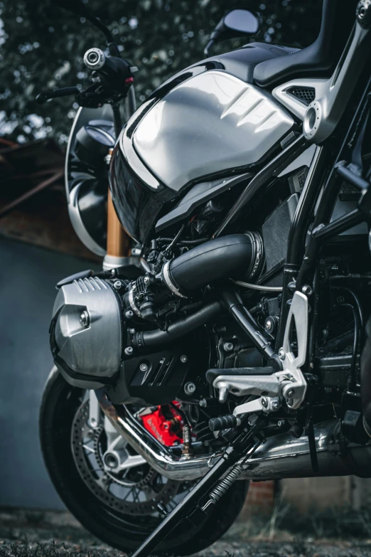 a black motorcycle parked next to a forest