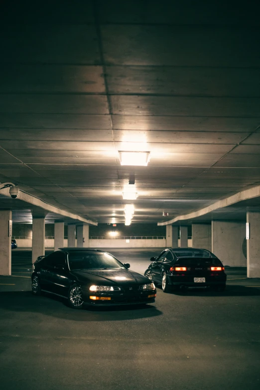 an empty parking garage with two cars parked in the space