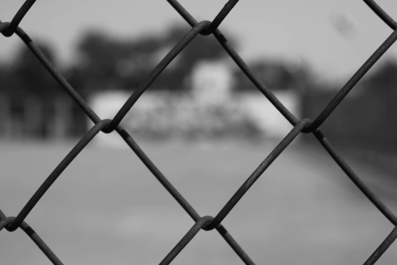 a black and white po of a fence with a road in the background