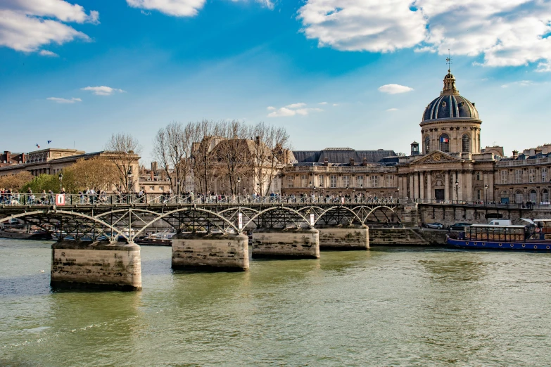 a large old building next to a river and a bridge