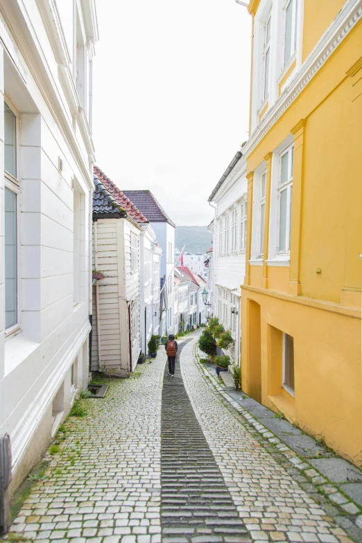 an alley way in a small town with a person walking down one side