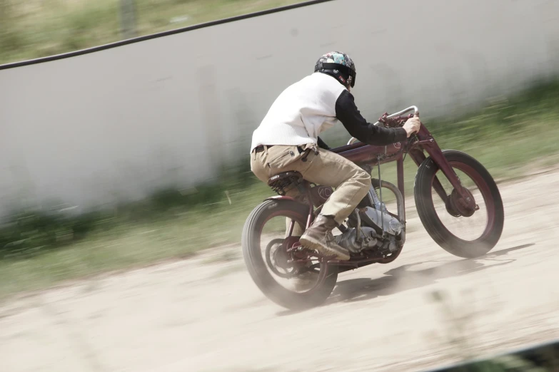 a man riding a motorcycle on a dirt road