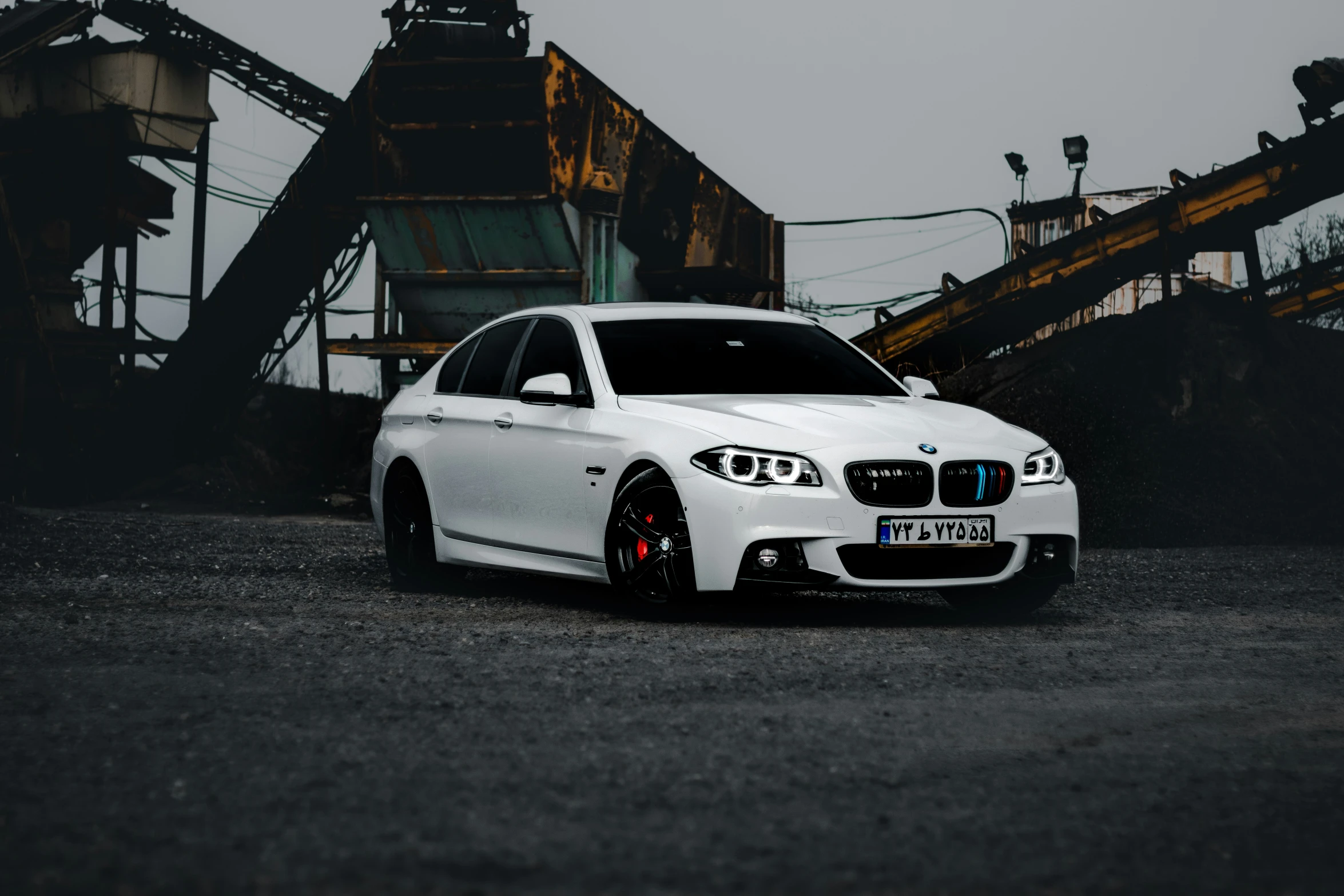 white car in a large industrial yard with dark background