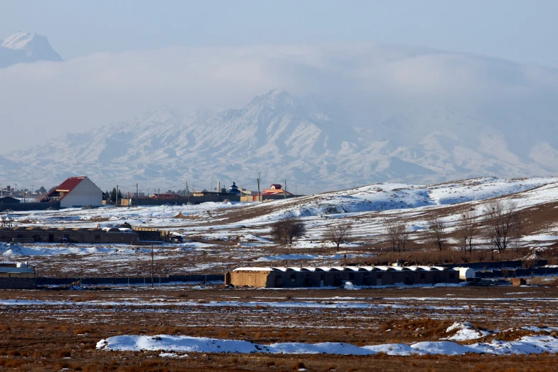 the snow covered landscape in wintertime with a mountain behind it