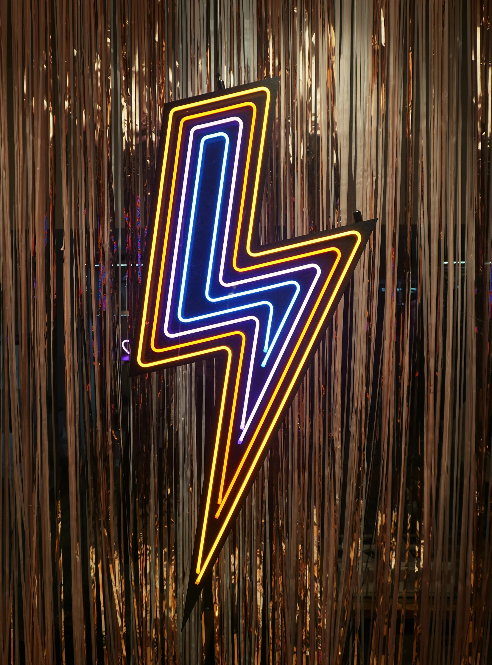 a large neon sign on a wall near lights