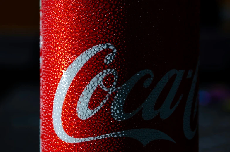 close up of a coca - cola can with its white speckle