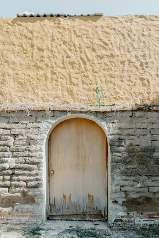 a brick wall and doorway of an old building