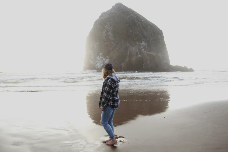 a woman is looking at the water and mountains