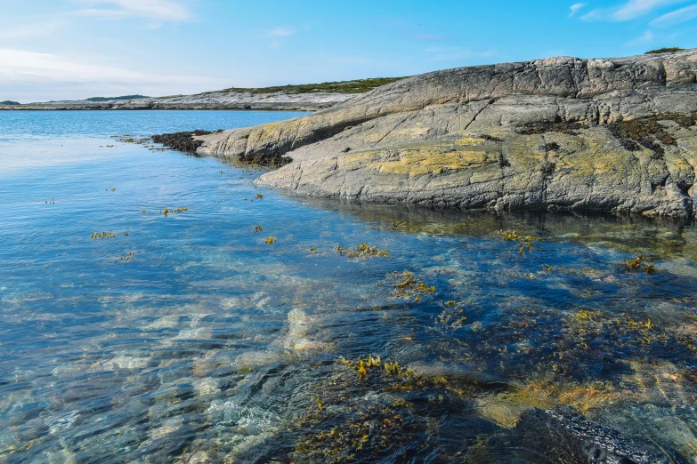 there is clear water between two rocks at the edge of the sea