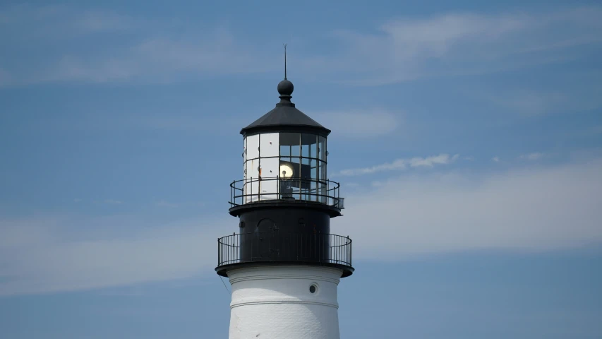 a black and white lighthouse with a clock on it