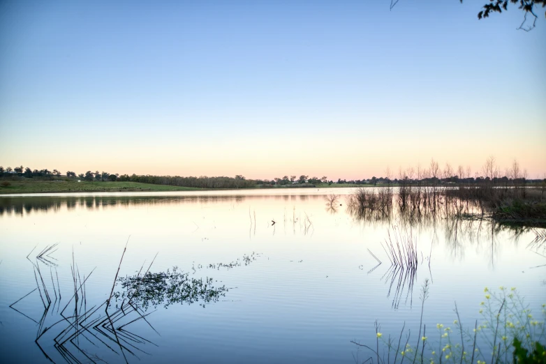 the sky is reflected in the still water of a lake