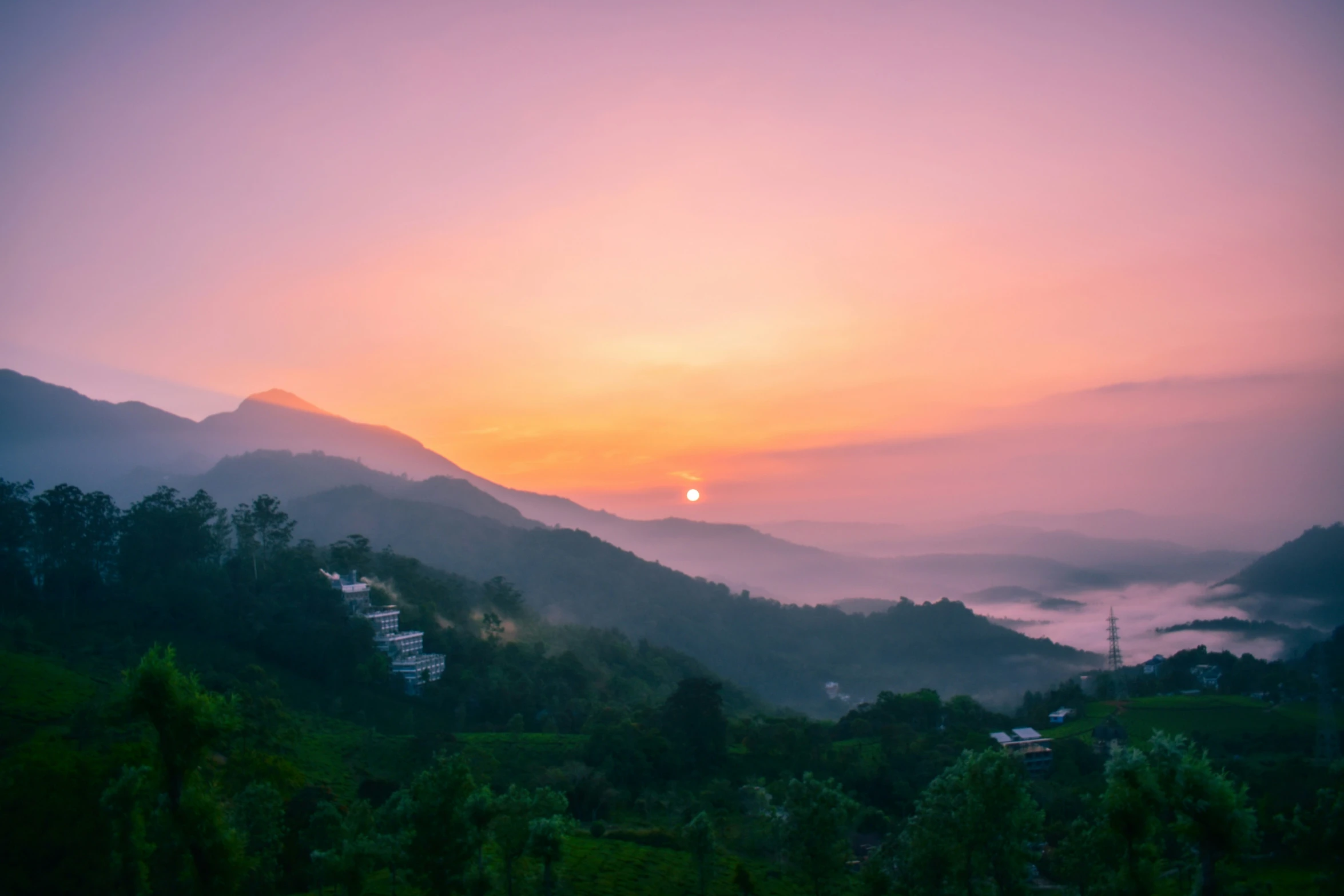 an orange sunset seen from the top of a mountain