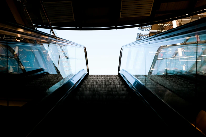 escalators going up in a dark place with bright lights