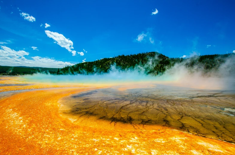 an aerial view of a geyser filled with steam rising from it