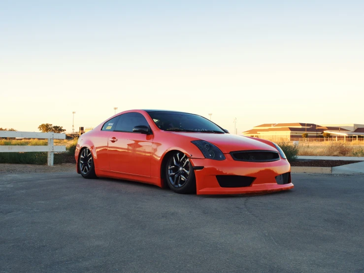 the bright orange sports car is parked on the road