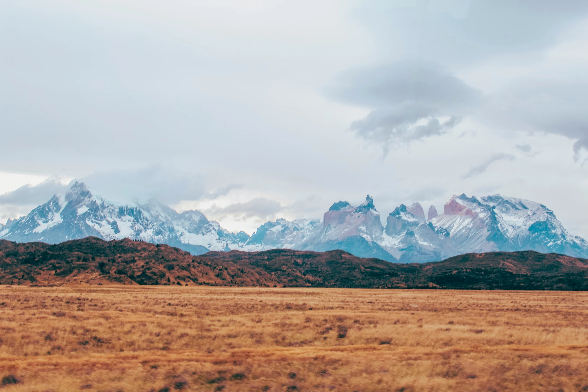 some big mountains and a field with some grass