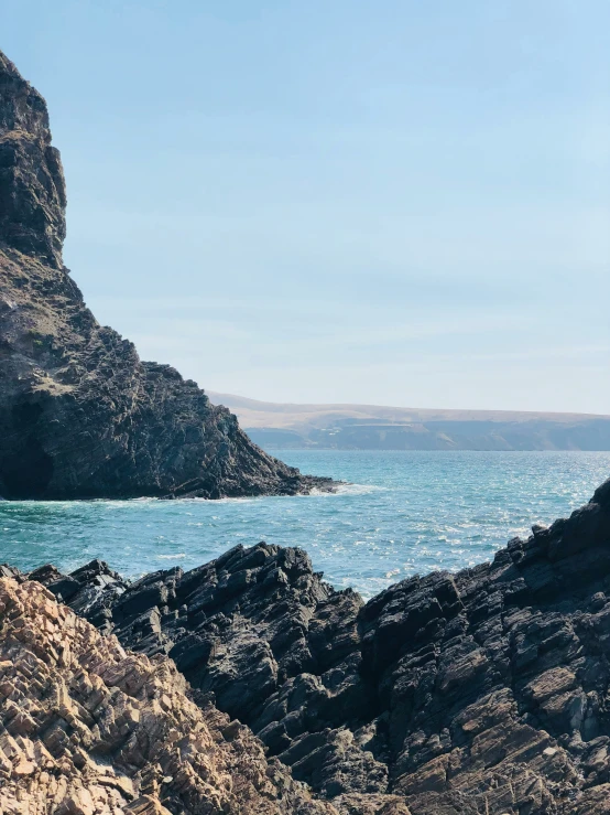 rocks and a body of water at the end of a cliff