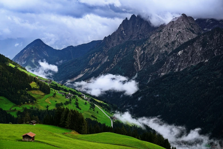 the mountains covered with mist covered clouds and grass