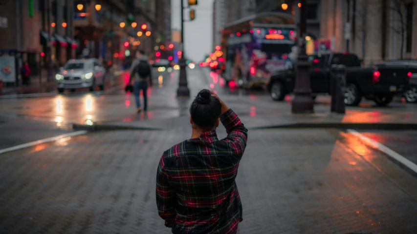 a woman looking down a city street with a traffic light in the background