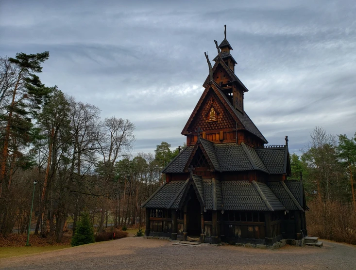 a tall wooden church in the middle of a forest