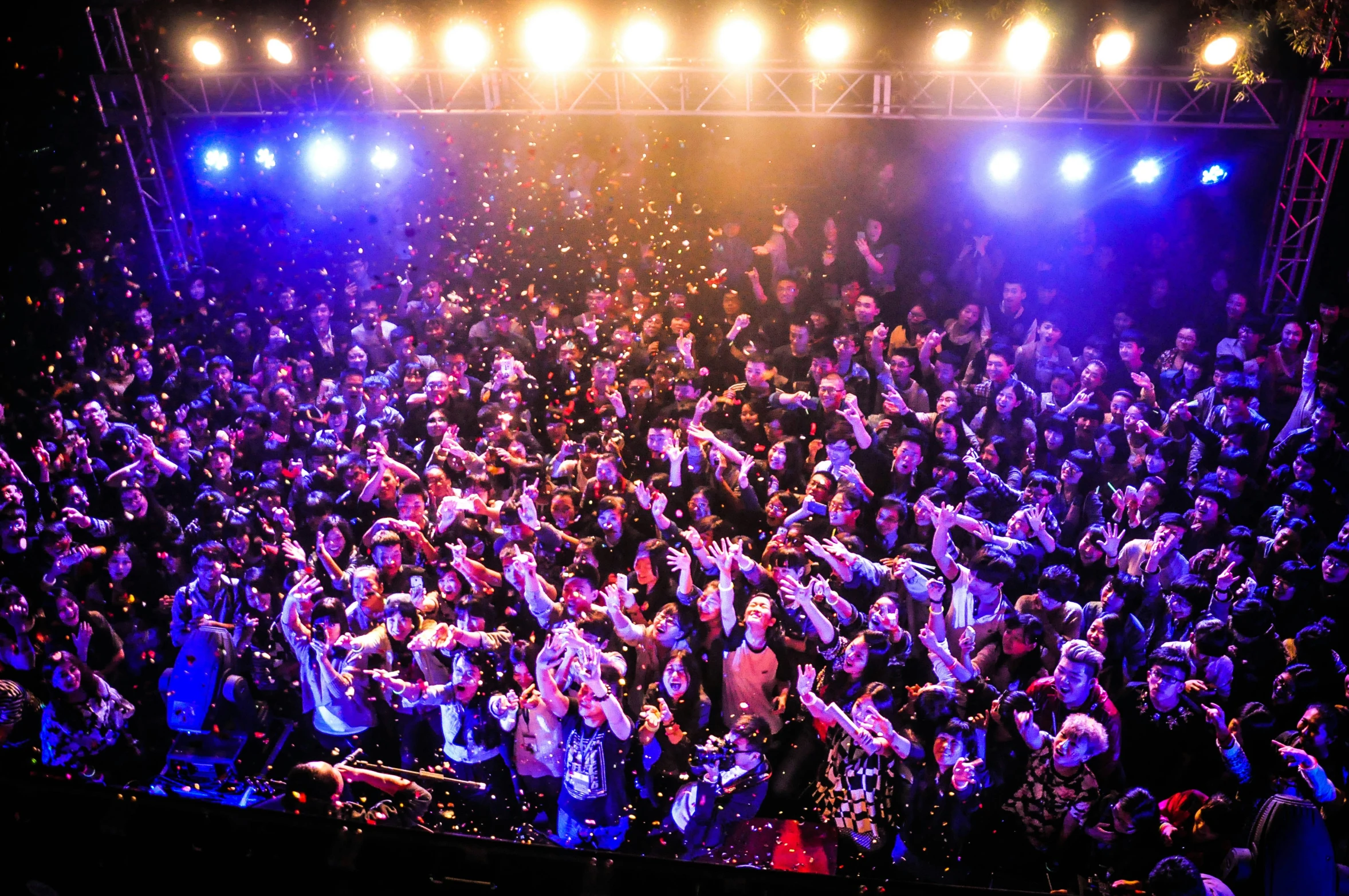 a large crowd is in the spotlight at a concert